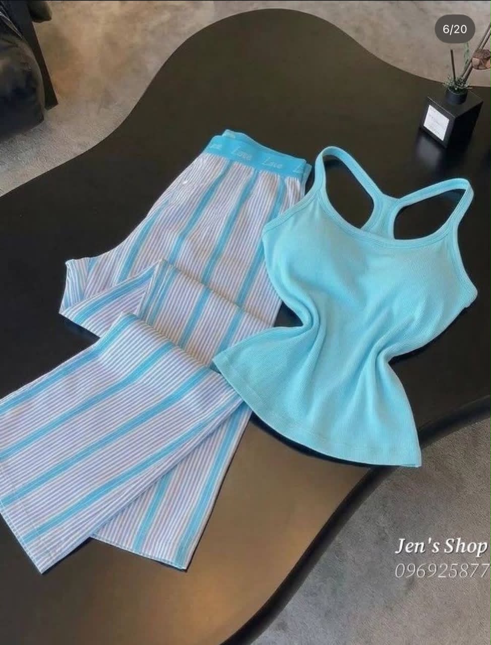 Sky blue ribbed racerback tank top paired with blue and white striped lounge pants on a dark surface.