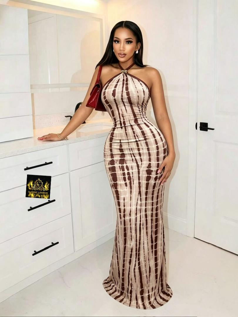 Model wearing a brown and cream tie-dye halter neck maxi dress with a gold-tone neck ring accent indoors.